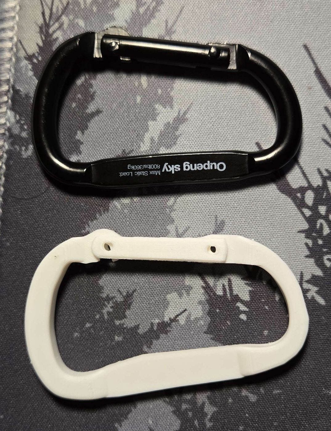 The finished 3D-printed carabiner beside the original for comparison, matching in size and shape.